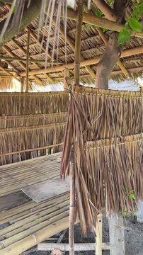 Traditional bamboo hut with thatched palm leaf roof in tropical garden