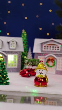 A large Christmas village with Christmas trees and snowmen near colorful houses