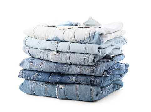 Stack of folded blue denim jeans and shirts in various washes, casual fashion and apparel concept, isolated on a white background