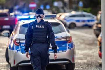 Policjantka z radiowozem w akcji wieczorem. Policja © FotoDax