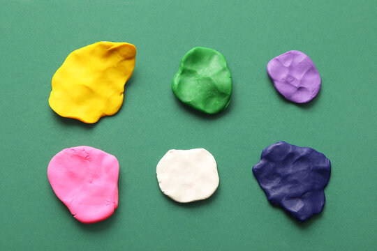 Many different colorful plasticine pieces on green background