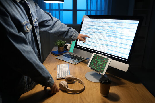 Male programmer pointing at modern computer in office, closeup