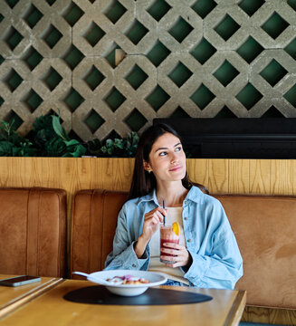 Young woman enjoying eating lunch at restaurant