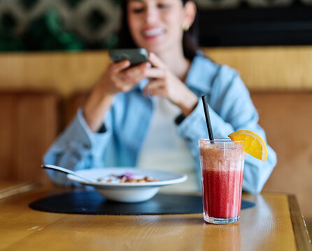 Young woman enjoying eating lunch and using a mobile phone and taking a selfie  at restaurant