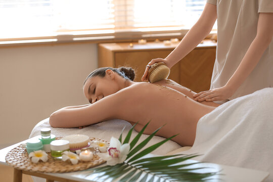 Young woman receiving back scrub massage in spa salon