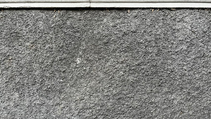 Rough textured gray stucco wall with a smooth white trim at the top provides a versatile background. © chodix