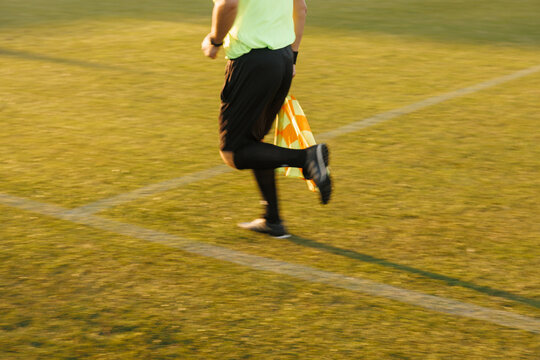 Assistant referee running on sideline during football match, soccer linesman in action and sports officiating concept