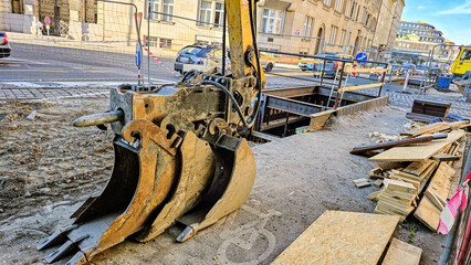 Road reconstruction and utility trenching with excavator attachments on a city street. Urban infrastructure repair and construction site concept. © Светлана Кушнир