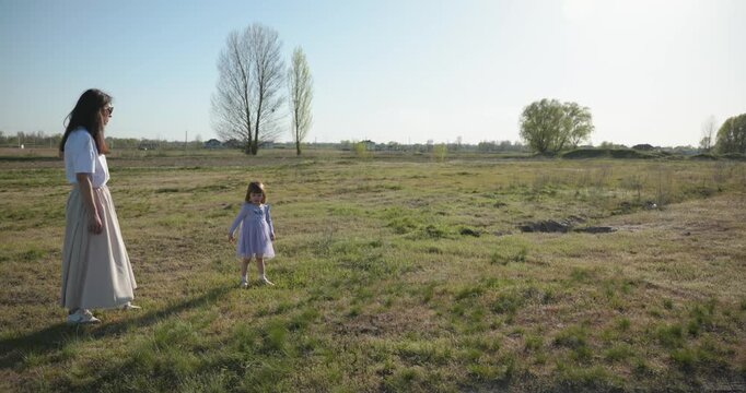 Mother with Children Throw Flying Disk Playing Outside. Family spend time together on nature. 4K 10-bit