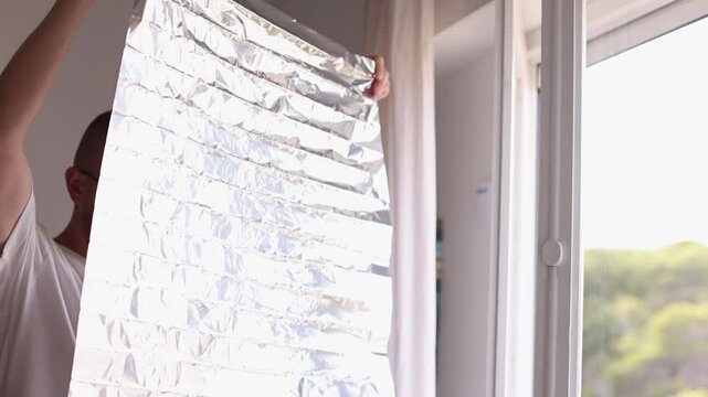 Man holding unrolled sun protection foil film for windows. 4k