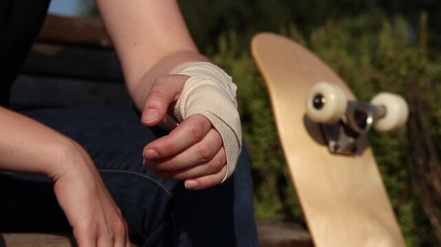 Skateboarder's wrist bandaged with elastic bandage. Hand with bandage after falling from skateboard. Sprain, dislocation or bruise during active recreation. Wrist injury. Injury concept