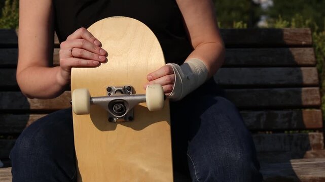 Skateboarder's wrist bandaged with elastic bandage. Hand with bandage after falling from skateboard. Sprain, dislocation or bruise during active recreation. Wrist injury. Injury concept