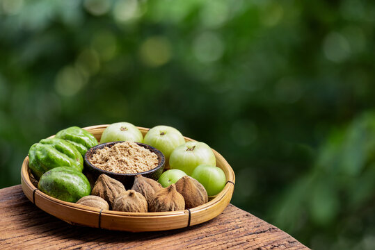 Indian Gooseberry ,terminalia chebula ,terminalia bellirica fruits and powder on natural background.