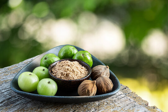 Indian Gooseberry ,terminalia chebula ,terminalia bellirica fruits and powder on natural background.