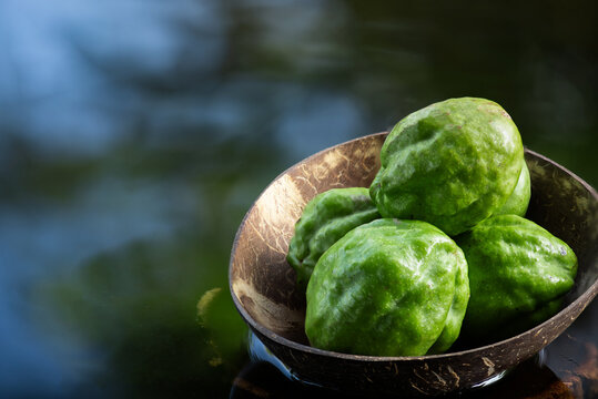 Terminalia chebula or Chebulic Myrobalans fruits placed on floating vessel against natural backdrop.