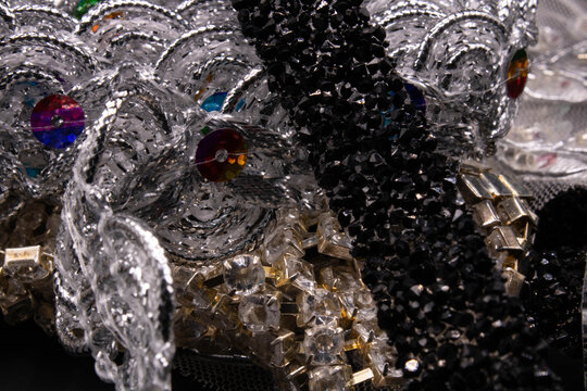 Layered craft textures featuring metallic silver braid, crystal rhinestone mesh, and dark sparkling ribbon