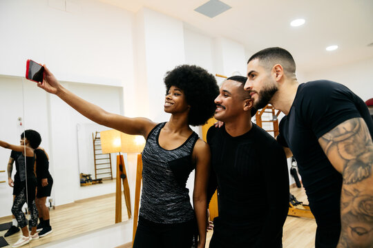 Friends taking selfie after workout in gym setting