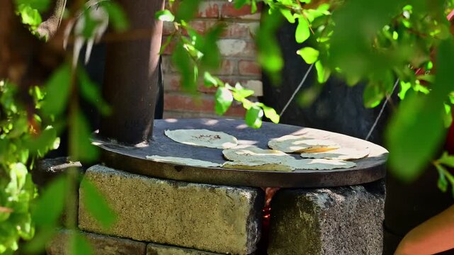 the process of making handmade tortillas on the clay griddle