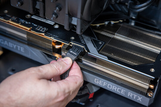 Technician connects a 12VHPWR or 12V-2x6 power connector to a powerful and expensive GeForce Gigabyte RTX graphics card. Building a top-end PC. Pavlodar, Kazakhstan - January 17, 2026