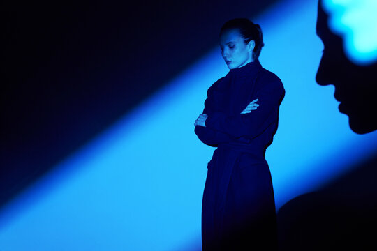 Woman in surreal blue lighting with mysterious shadow