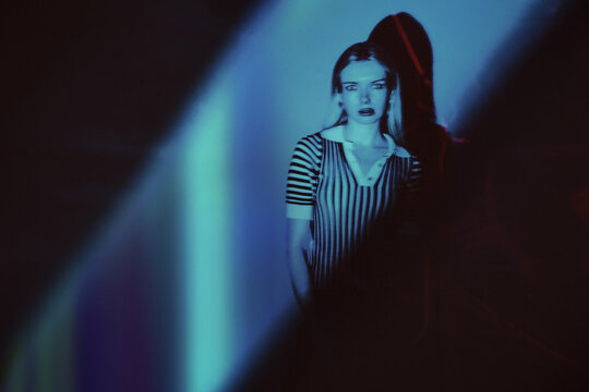 Mysterious figure in striped fashion with neon glow