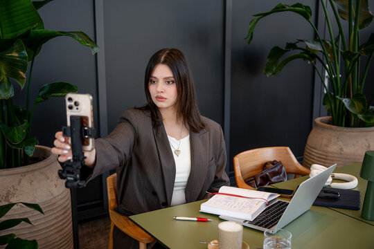 Businesswoman recording SMM video content in a cafe