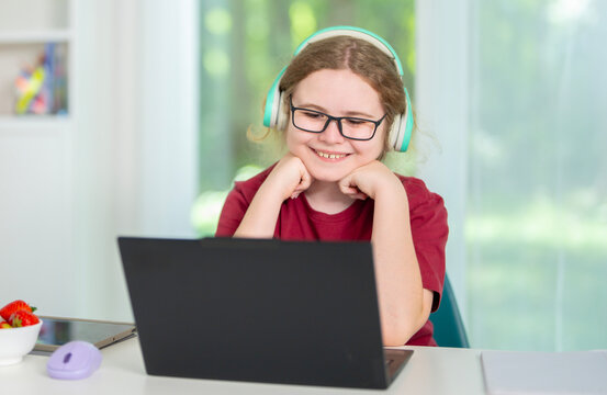 Class student listens with headset. Class learner studies with computer. Happy child enjoys class online. Young kid follows class lesson.