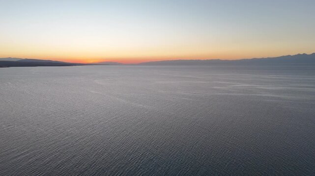 Stunning drone view of Issyk-Kul Lake at sunset, showcasing golden skies