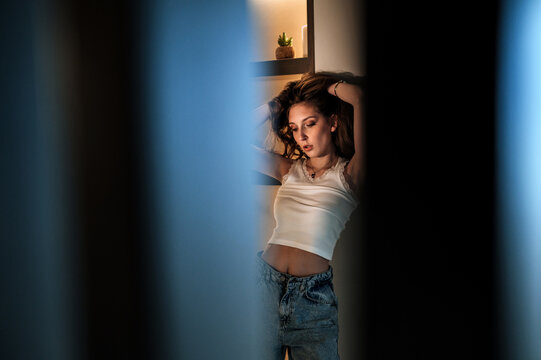 Young woman relaxing in cozy apartment at night at home