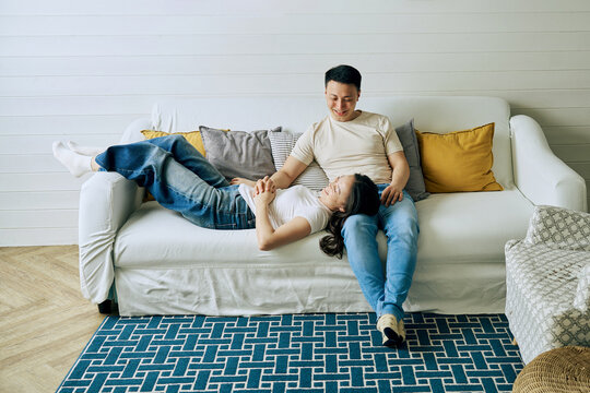 Relaxed couple share intimate moment on sofa at home