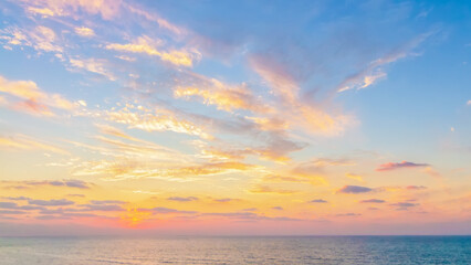 Fototapeta premium Wide horizontal soft focus minimalist sunset landscape sea or ocean, dramatic golden hour clouds, peaceful serene nature background. Copy space for web design, travel banner 