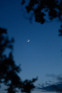 Crescent moon and planet in twilight sky