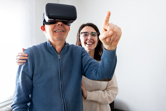 Senior man experiencing virtual reality headset with help