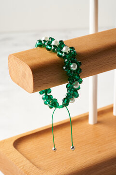 Green crystal bead bracelet with pearls on wooden stand