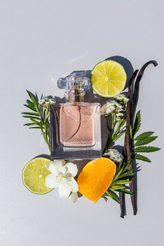 Citrus and vanilla perfume bottle with flowers flat lay