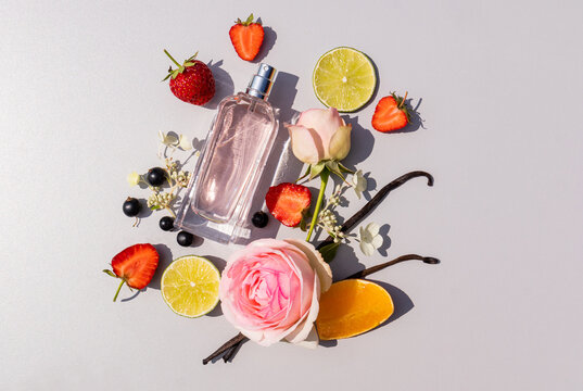 Perfume bottle with citrus, strawberry and rose flat lay
