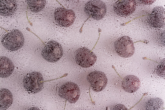 Cherries with water droplets on a clear surface