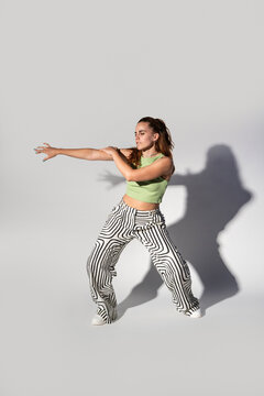 Urban woman dancer posing with dramatic studio shadow