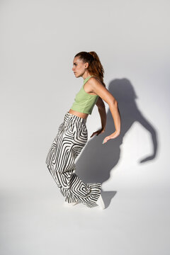 Urban woman dancer pose with dramatic studio shadow