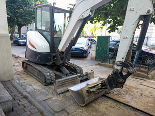 Compact excavator, compact design It is a zero-tail-swing model for digging and landscaping in tight urban spaces. Rubber tracks for mobility on various terrains and a front dozer blade for grading.  © Jacek