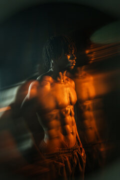 Muscular African man in dramatic orange light