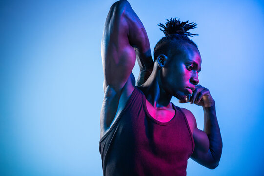 African man pose in neon light with muscular physique
