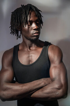African man with crossed arms in black tank top