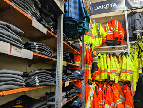 Gaspesie, Quebec, 06 June 2026 : High-visibility safety workwear and industrial apparel are displayed on shelves and hangers in a retail store.