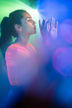 Latin urban dancer with closed eyes in neon light