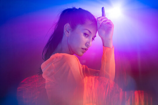 Latin woman urban dancer posing in neon nightclub light