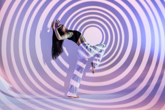 Latin woman urban dancer in hypnotic spiral light projection