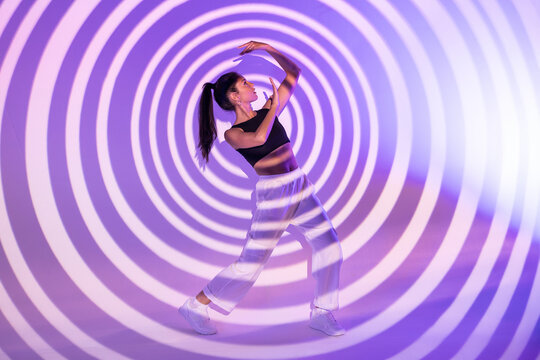 Latin urban dancer posing in hypnotic spiral light