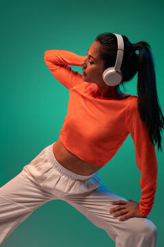 Latin woman dancer wearing headphones in urban style