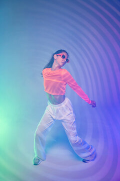 Latin woman dance in neon light with psychedelic backdrop